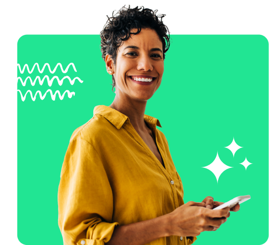 Woman smiling at the camera holding a phone on a green background