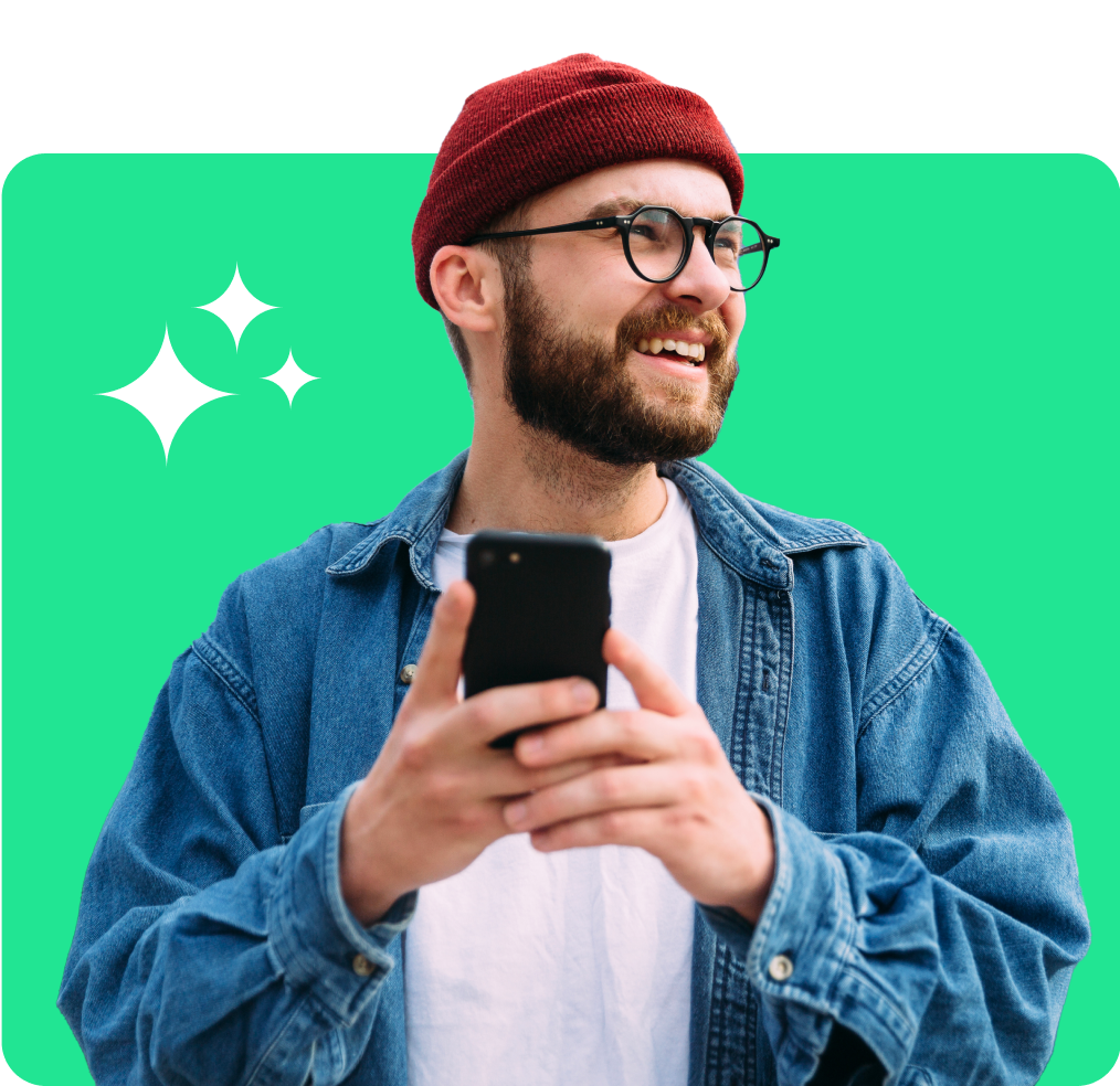 Man holding a phone and smiling on a green background